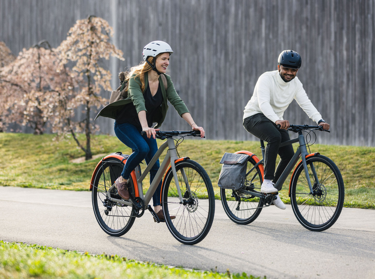 Eine lächelnde Frau und ein lächelnder Mann fahren mit ihren BMC 257 City Bike Modellen durch die Stadt